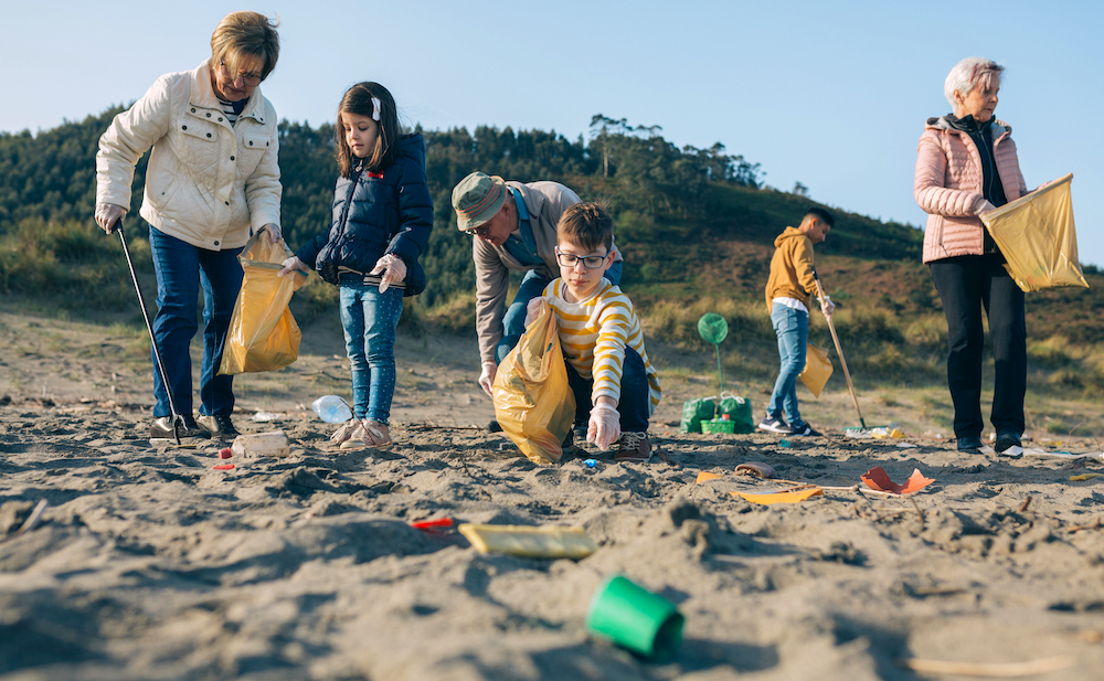 Group of volunteers picking up trash on the beach
